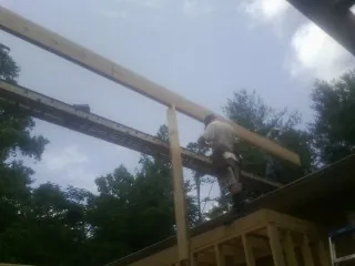 Carpenter setting a ridge beam over a new addition frame — Ice Dam Removal by Roofing Brothers in White House