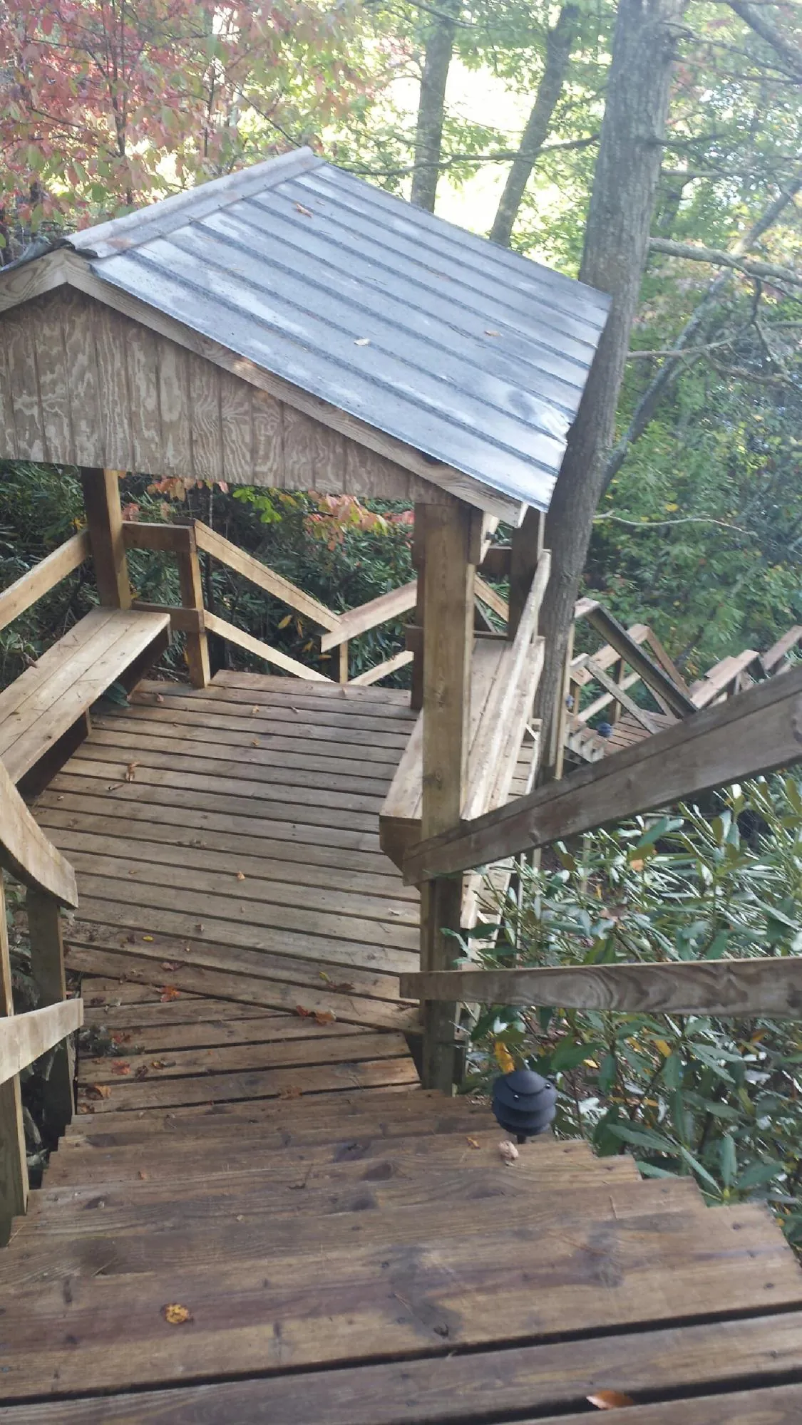 Metal roofed shelter over wooden steps on a wooded walkway — Skylight Repair & Installation work by our crew in White House