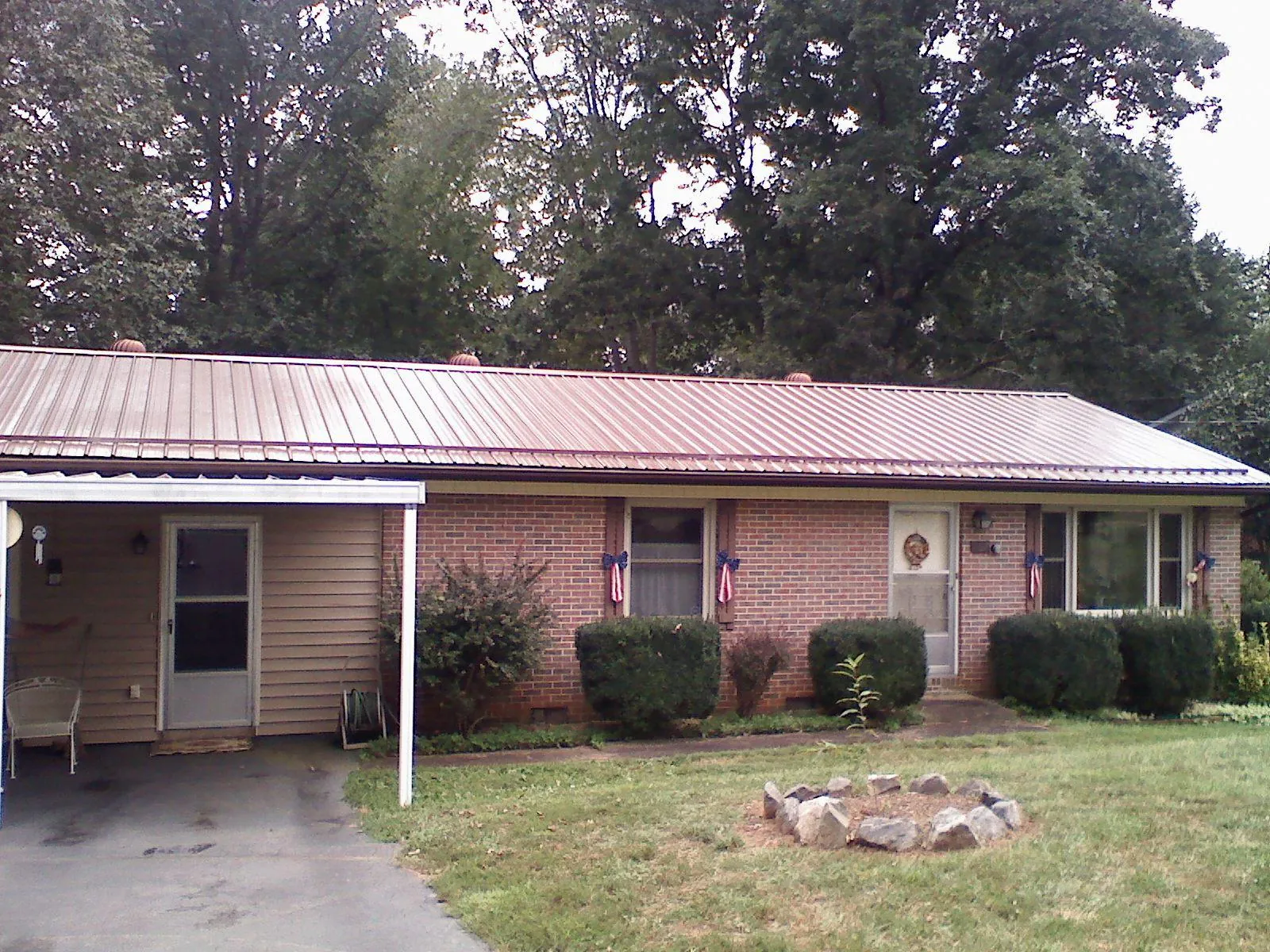 Bronze metal roof and carport on a brick ranch home — Roof Repair work by our crew in White House